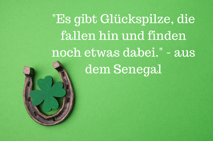 4 blättriges Kleeblatt mit Hufeisen mit dem Spruch: "Es gibt Glückspilze, die fallen hin und finden noch etwas dabei." - aus dem Senegal