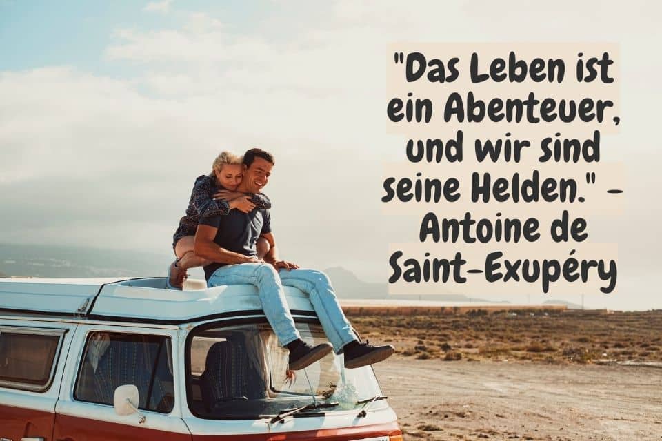 Mann und Frau sitzen auf dem Dach ihres Campers. Zitat: "Das Leben ist ein Abenteuer, und wir sind seine Helden." - Antoine de Saint-Exupéry