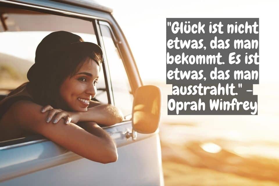 Strahlende Frau streckt sein Kopf aus dem Autofenster heraus und Zitat: "Glück ist nicht etwas, das man bekommt. Es ist etwas, das man ausstrahlt." - Oprah Winfrey