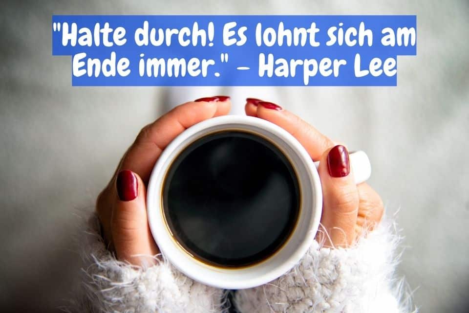 Frauenhände halten eine Tasse Kaffee mit Spruch: "Halte durch! Es lohnt sich am Ende immer." - Harper Lee
