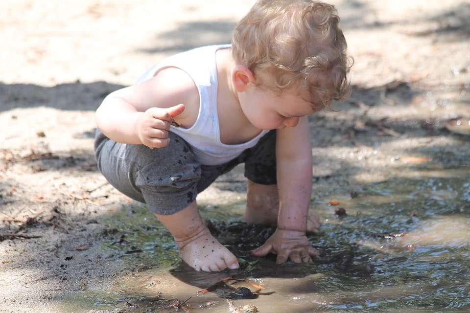 L'enfant joue à la flaque d'eau