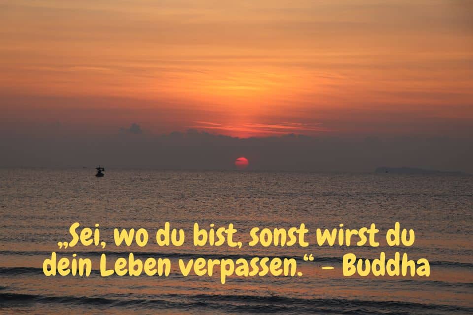 Sonnenaufgang, oranger Horizon am Meer, Fischerbot und Zitat:„Sei, wo du bist, sonst wirst du dein Leben verpassen.“ - Buddha