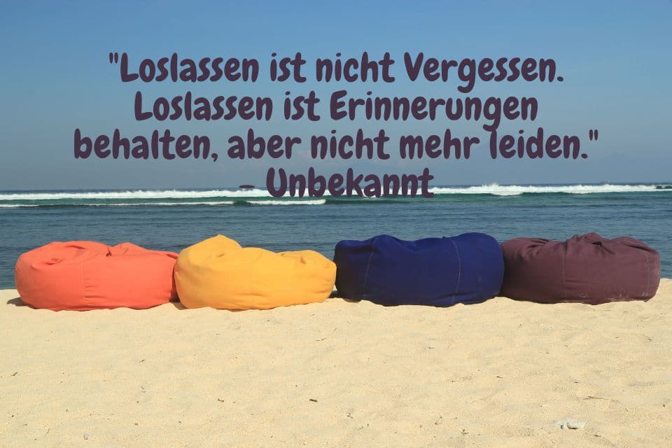 Verschiedenfarbige Kissen am Strand und Zitat: "Loslassen ist nicht Vergessen. Loslassen ist Erinnerungen behalten, aber nicht mehr leiden." - Unbekannt