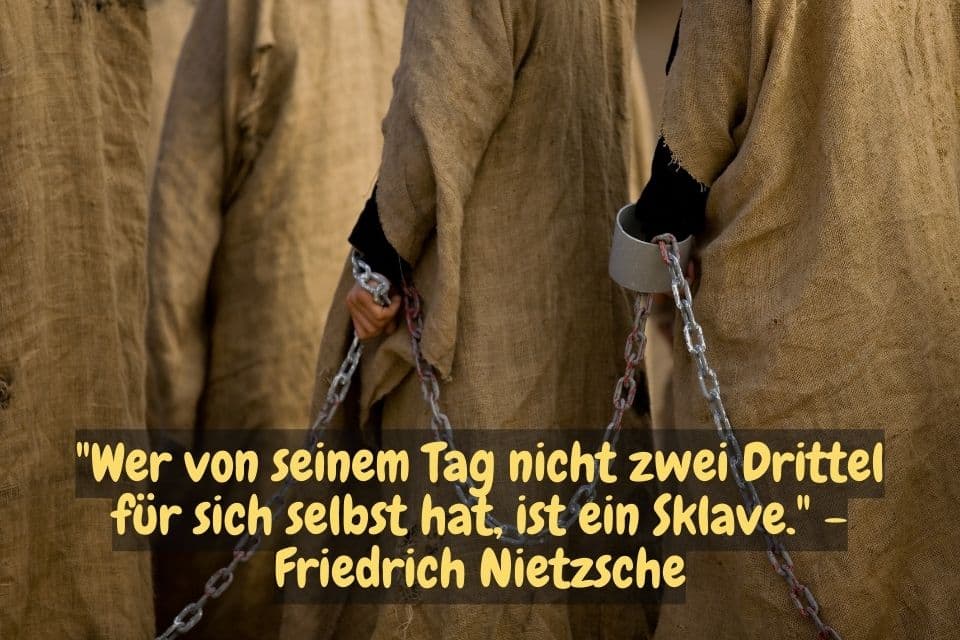 Menschliche Gestalten in einer Rehe angekettet und Zitat: "Wer von seinem Tag nicht zwei Drittel für sich selbst hat, ist ein Sklave." - Friedrich Nietzsche