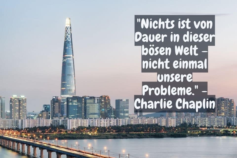 Moderne Stadt mit Zitat: "Nichts ist von Dauer in dieser bösen Welt – nicht einmal unsere Probleme." - Charlie Chaplin