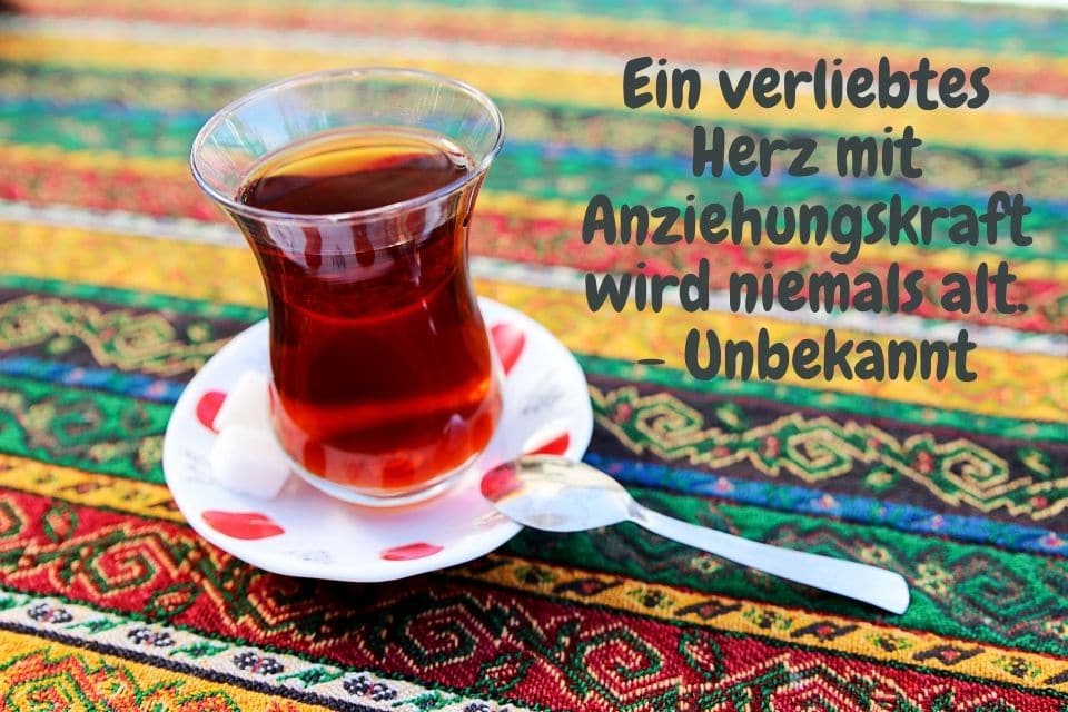 Türkischer Tee auf bunter Tischdecke mit Zitat: Ein verliebtes Herz mit Anziehungskraft wird niemals alt. - Unbekannt