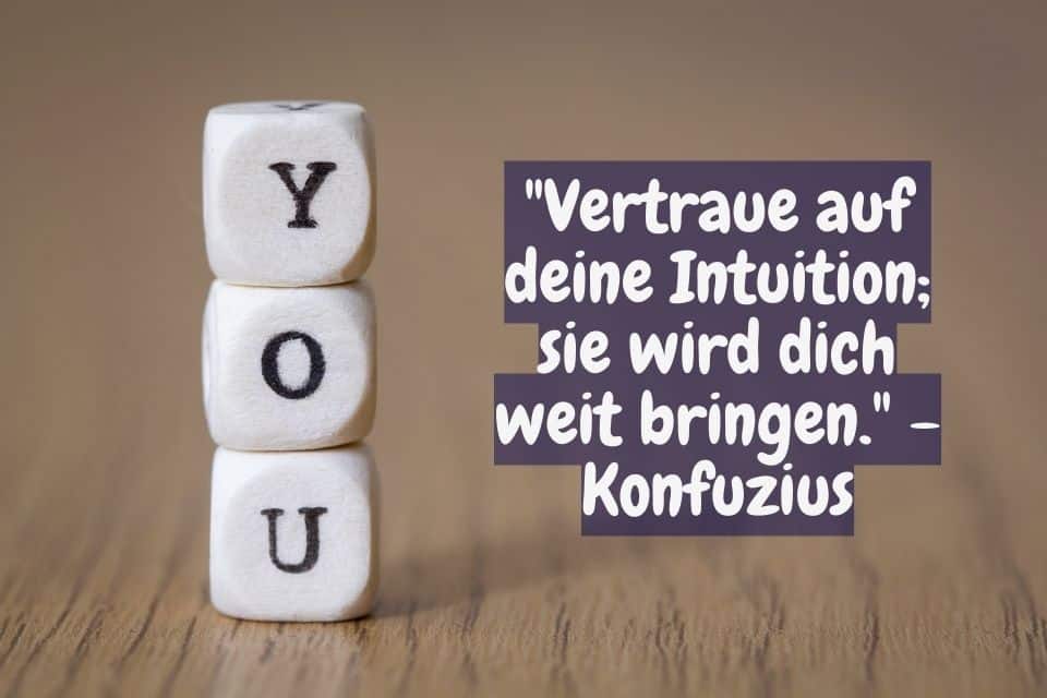 Drei Würfel darauf steht "YOU" und Zitat: "Vertraue auf deine Intuition; sie wird dich weit bringen." - Konfuzius