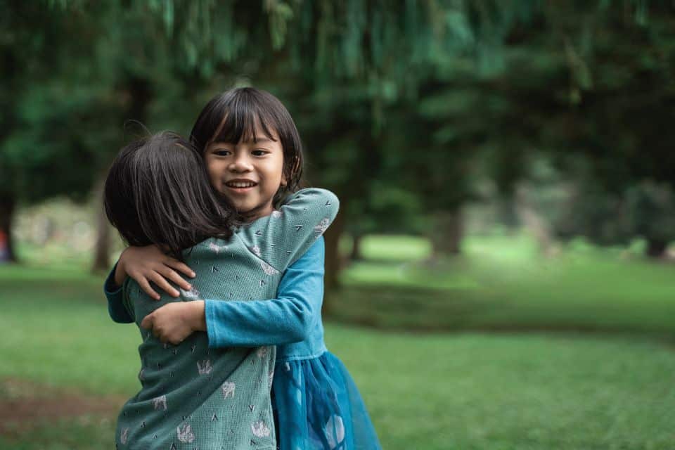 Zwei asiatische Kinder umarmen sich - Verzeihung Sprüche | Geschenk inneren Friedens