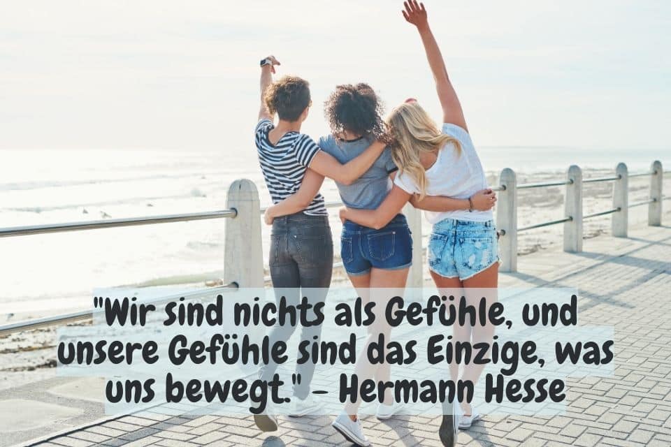 Drei Frauen jubelnd am Meer. Zitat: "Wir sind nichts als Gefühle, und unsere Gefühle sind das Einzige, was uns bewegt." - Hermann Hesse