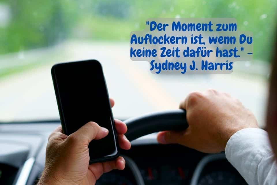 Mann fährt Auto und hantiert am Handy. Zitat:"Der Moment zum Auflockern ist, wenn Du keine Zeit dafür hast." - Sydney J. Harris