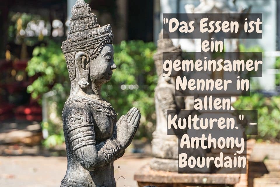 Buddha Statue und Zitat: "Das Essen ist ein gemeinsamer Nenner in allen Kulturen." - Anthony Bourdain