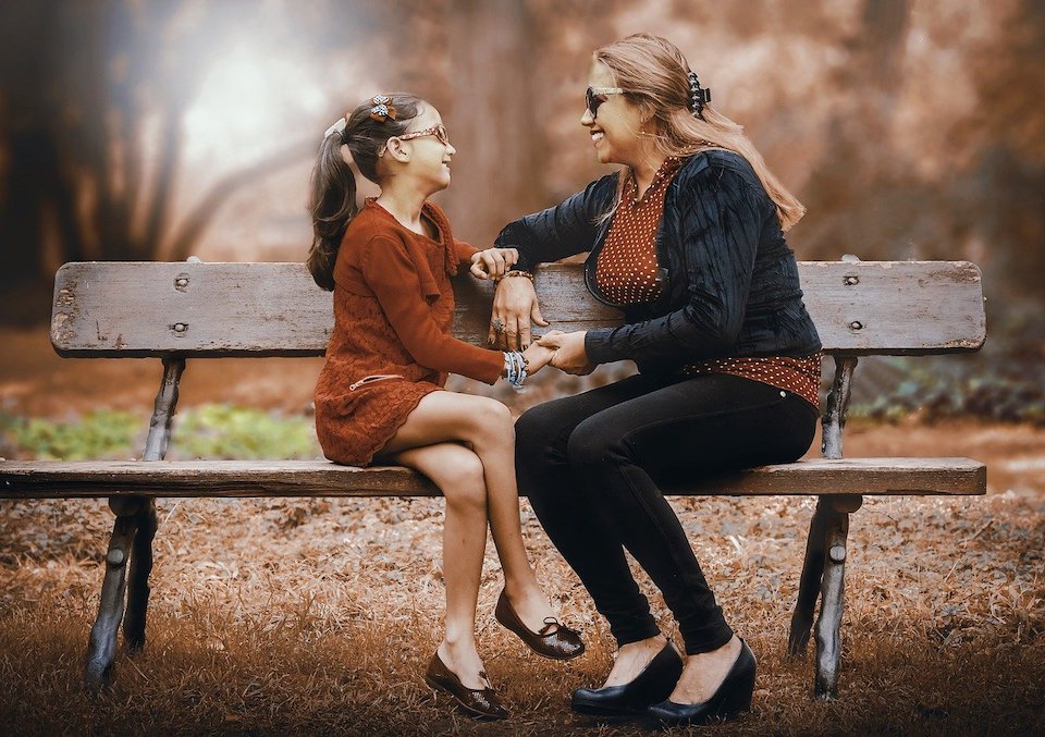 Gute Gespräche führen Mutter und Tochter auf einer bank im Park